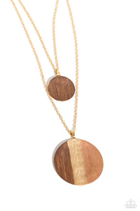 Two strands of classic gold chains fall into tiered layers as they cascade down the chest. Varying sizes of gold discs hammered in rippling texture and painted with a glossy Iced Coffee and brown slide along each chain in a dizzying display, with a thin line of gold peeking at the center of the lowermost exaggerated pendant.  Sold as one individual necklace. Includes one pair of matching earrings.
