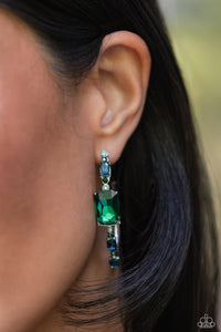 Encrusted in round and emerald-cut aquamarine and emerald gems, some featuring an iridescent sheen, an exaggerated oblong silver hoop curls around the ear, refracting light in a dramatic, knockout finish. Earring attaches to a standard post fitting. Hoop measures approximately 2" long. Due to its prismatic palette, color may vary.  Sold as one pair of hoop earrings.