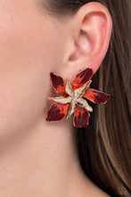 Load image into Gallery viewer, Featuring a warped, metallic texture, a gold flower blooms atop the ear, while a larger gold warped flower featuring Red Dahlia and Burnt Sienna accents adds a vibrant pop of color to the whimsical centerpiece. Earring attaches to a standard post fitting.  Sold as one pair of post earrings.
