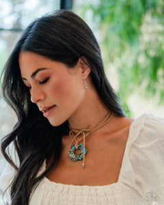 Featuring brown and black marbling, an airy turquoise flower is knotted at the bottom of a lengthened strand of brown suede for a southwestern-inspired statement. Features an adjustable tie closure.  Sold as one individual necklace. Includes one pair of matching earrings.