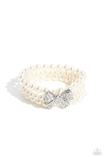 Strung along elastic stretchy bands, three strands of high-sheen classic white pearls wrap around the wrist. Featured atop the pearly collection, a loopy silver bow, filled with glistening white rhinestones is attached to the center of the wrist for a dramatically dazzling finish.  Sold as one individual bracelet.