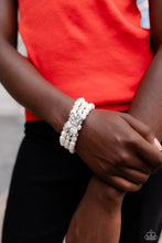 Load image into Gallery viewer, Strung along elastic stretchy bands, three strands of high-sheen classic white pearls wrap around the wrist. Featured atop the pearly collection, a loopy silver bow, filled with glistening white rhinestones is attached to the center of the wrist for a dramatically dazzling finish.  Sold as one individual bracelet.
