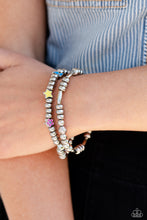 Load image into Gallery viewer, A strand of textured, cylindrical, and round high-sheen silver beads combine with a single strand of silver beads, sporadically infused with vivacious charm beads to create an energetic stack of stretchy bracelets. The colorful beaded stack features a yellow star, blue lightning bolt, green money bag, orange tropical flower, red lips, blue and green earth, pink and purple flower, and a pink heart charm with the words &quot;love me&quot; for a youthful finish.  Sold as one set of two bracelets.

