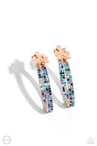 The front half and lower inner curve of a textured shiny copper hoop are encrusted in dazzling ombré shades of blue for a flawless look. Earring attaches to a standard clip-on fitting. Hoop measures approximately 1" in diameter. Due to its prismatic palette, color may vary.   Featured inside The Preview at Made for More! Sold as one pair of clip-on earrings.
