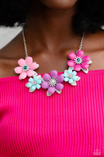 Dotted with dainty Harbor Blue, aquamarine, and rose rhinestone centers, dainty silver flowers bloom against a backdrop of glossy acrylic flowers in Aurora Pink, Rose Violet, Cattleya Orchid, and Spun Sugar hues. Each flower, varying in size, blossoms across a textured collection of silver leaves below the collar, invoking a festive spirit. Features an adjustable clasp closure.  Sold as one individual necklace. Includes one pair of matching earrings.