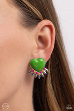 Load image into Gallery viewer, A Classic Green heart pressed in a sleek silver frame stands out at the ear. Textured silver leaves flare out from a curved cluster of Rose Violet and orange seed beads that adorn the bottom of the heart display, creating a spring-inspired fringe. Earring attaches to a standard clip-on fitting.  Sold as one pair of clip-on earrings.
