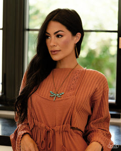 Featuring a classic brass chain, various cuts of turquoise stone are passed into an oversized, airy brass dragonfly pendant for a rustically earthy centerpiece. Features an adjustable clasp closure. As the stone elements in this piece are natural, some color variation is normal.  Sold as one individual necklace. Includes one pair of matching earrings.