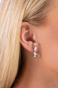 A glassy collection of white round, marquise-cut, and emerald-cut rhinestones and gems are pronged in place along a curved silver bar. Features a sleek surface for sliding ability to desired position on the ear. Due to its structure, adjusting capability is limited.  Sold as one pair of illusion post earrings.