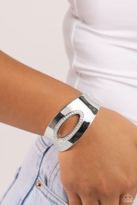 Featuring an airy asymmetrical, white rhinestone-encrusted cutout, a sleek silver cuff with beveled edges wraps around the wrist for a bold, refined look. Features a hinged closure.  Sold as one individual bracelet.