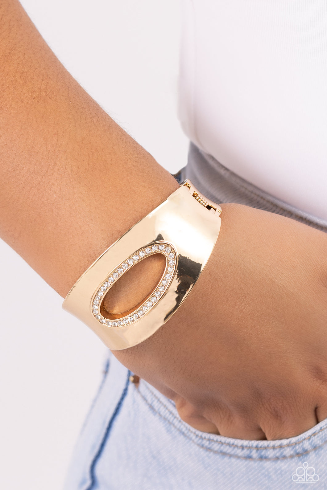 Featuring an airy asymmetrical, white rhinestone-encrusted cutout, a sleek gold cuff with beveled edges wraps around the wrist for a bold, refined look. Features a hinged closure.  Sold as one individual bracelet.