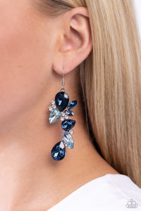 Featuring various shades of blue, a glittery collection of oversized teardrop, round, and marquise-cut gems cluster and curve in place along the ear, creating a glamorous lure. Dainty white rhinestones sporadically dot across the canvas, further drawing the eye to the faceted oversized detail. Earring attaches to a standard hanging fishhook fitting. Due to its prismatic palette, color may vary. Sold as one pair of earrings.