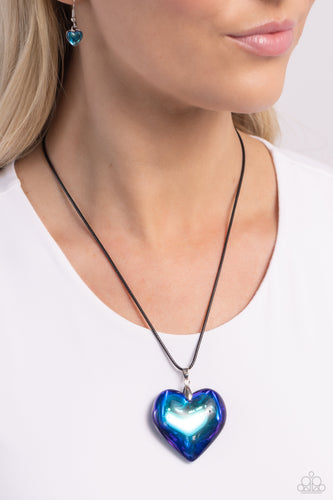 Wrapped in a blue UV finish, an oversized heart pendant glides along a lengthened strand of black cord across the chest for a stellar flair. Features an adjustable clasp closure.  Sold as one individual necklace. Includes one pair of matching earrings.