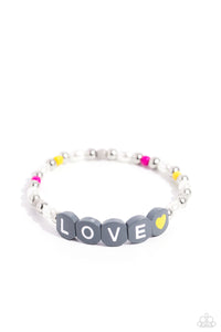 Infused on an elastic stretchy band, white pearls, gray, hot pink, and yellow seed beads, silver studs, and gray beads spelling out the word "LOVE" with a yellow heart bead aside it wraps around the wrist for a sentimental, youthful display.  Sold as one individual bracelet.