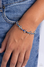 Load image into Gallery viewer, Set in silver square fittings, various multicolored rhinestones gleam around the wrist. Infused along the design, sleek silver letters spell out the word &quot;TRUST&quot; for an inspirational finish. Features an adjustable clasp closure. Due to its prismatic palette, color may vary.  Sold as one individual bracelet.
