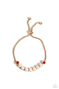  Delicately attached to a dainty gold box chain, thick circular gold fittings spell out the word "BELIEVE" across a white-painted backdrop with red-painted hearts embellishing the ends of the word, creating a sleek inspiring display. Features an adjustable sliding bead closure.  Sold as one individual bracelet. 