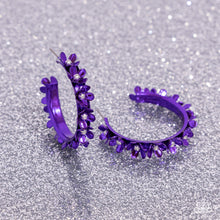 Load image into Gallery viewer, Dipped in a purple hue, a hollowed-out hoop curls around the ear. Featuring silver beaded centers, metallic purple flowers bloom along the curl of the hollow of the hoop for a fashionable display. Earring attaches to a standard post fitting. Hoop measures approximately 1 1/4&quot; in diameter. Sold as one pair of hoop earrings.
