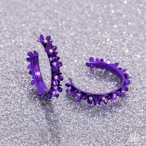 Dipped in a purple hue, a hollowed-out hoop curls around the ear. Featuring silver beaded centers, metallic purple flowers bloom along the curl of the hollow of the hoop for a fashionable display. Earring attaches to a standard post fitting. Hoop measures approximately 1 1/4" in diameter. Sold as one pair of hoop earrings.