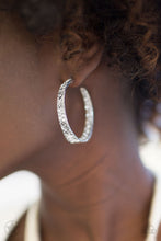 Load image into Gallery viewer, The front facing surface of a chunky silver hoop is dipped in brilliantly sparkling rhinestones while light-catching texture wraps around the back. The interior of the hoop features the opposite pattern, creating the illusion of a full hoop of blinding Blockbuster rhinestones. Earring attaches to a standard post fitting. Hoop measures 1 3/4&quot; in diameter.  Sold as one pair of hoop earrings.
