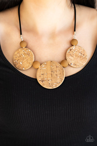 Featuring white accents, cork-like frames and brown matte beads are threaded along an invisible wire below the collar for a statement-making look. Features an adjustable clasp closure.  Sold as one individual necklace. Includes one pair of matching earrings.