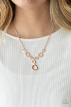 Load image into Gallery viewer, Irregular shaped rose gold rings connect to a rose gold chain as they make their way across the collar. Two rings dangle from the center for a stylish avant-garde fashion. Features an adjustable clasp closure. Includes one pair of matching earrings.
