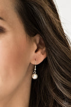 Load image into Gallery viewer, Small white pearl hanging from a silver fish hook earring.
