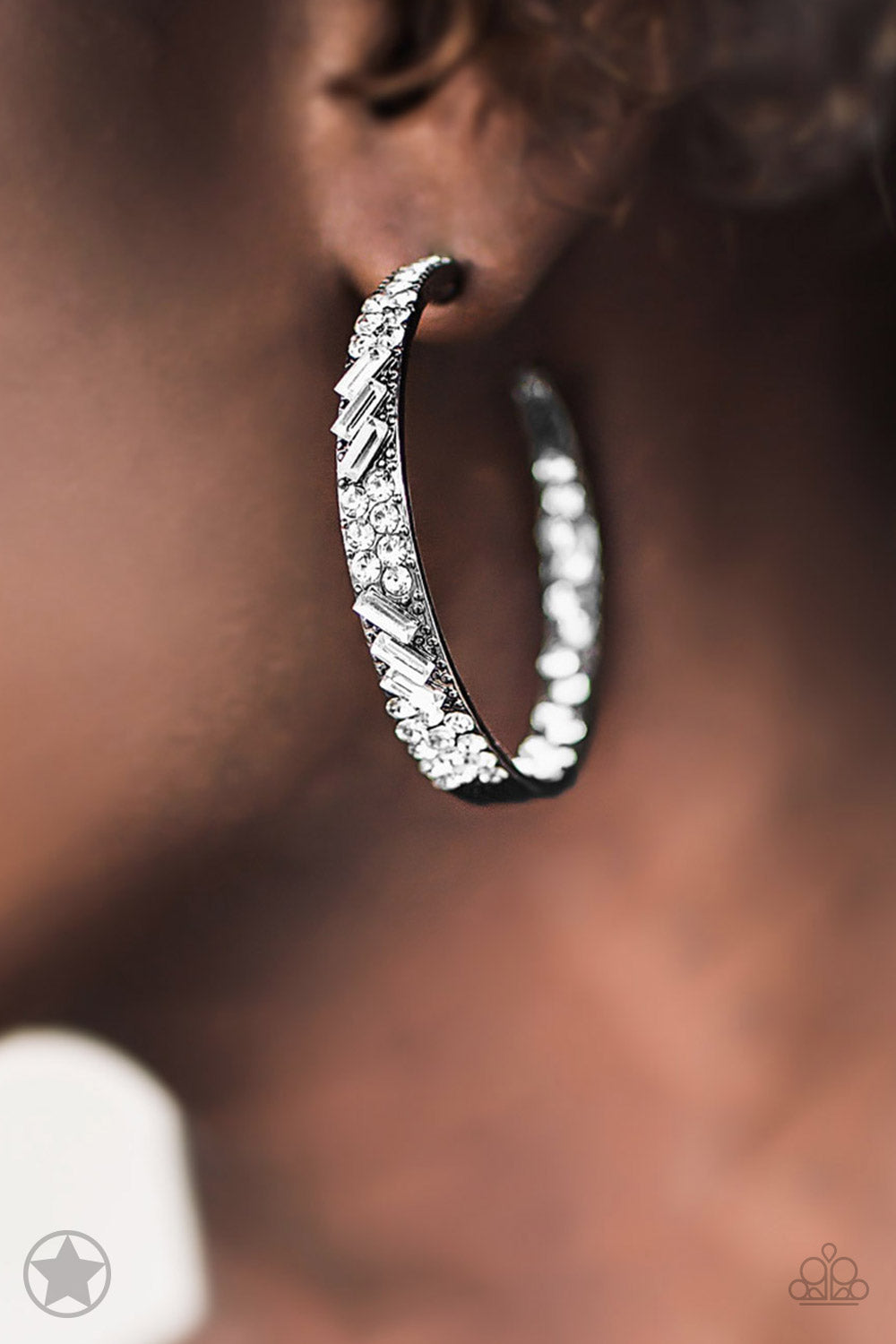 The front facing surface of a chunky gunmetal hoop is dipped in brilliantly sparkling rhinestones while light-catching texture wraps around the back. The interior of the hoop features the opposite pattern, creating the illusion of a full hoop of blinding Blockbuster rhinestones. Earring attaches to a standard post fitting. Hoop measures 1 3/4