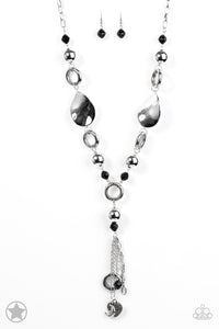 Long chain of black crystalized beads, curved plates of silver with a pearly finish, and chunky silver rings lead down to a tassel of chains and charms, including a crescent moon and a heart.  Sold as one individual blockbuster necklace with matching earrings.