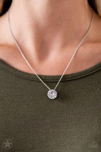 A single rhinestone sparkles brilliantly at the bottom of a dainty silver chain, creating a stunning solitaire design. Features an adjustable clasp closure.  Sold as one individual blockbuster necklace with matching earrings.